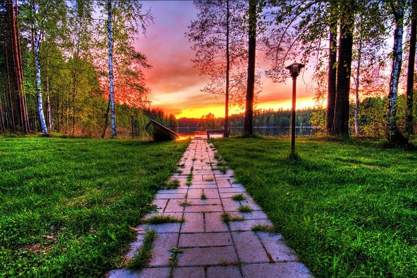 Passerelle à travers le parc au lac au coucher du soleil