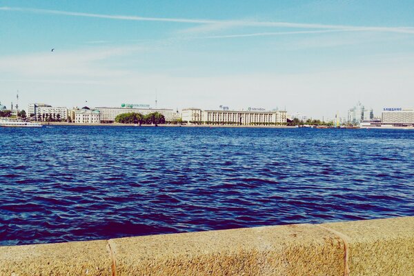 The parapet of the embankment against the backdrop of the Neva and St. Petersburg