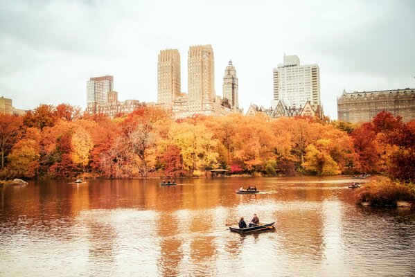 Катающиеся по воде в лодках люди на фоне осеннего Нью-Йорка в США