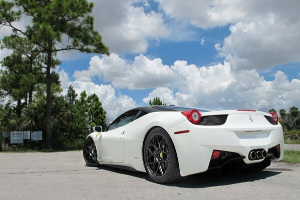 A snow-white Ferrari against a background of blue sky and the same snow-white clouds