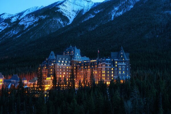 Edificio notturno del Parco nazionale canadese con montagne innevate sullo sfondo