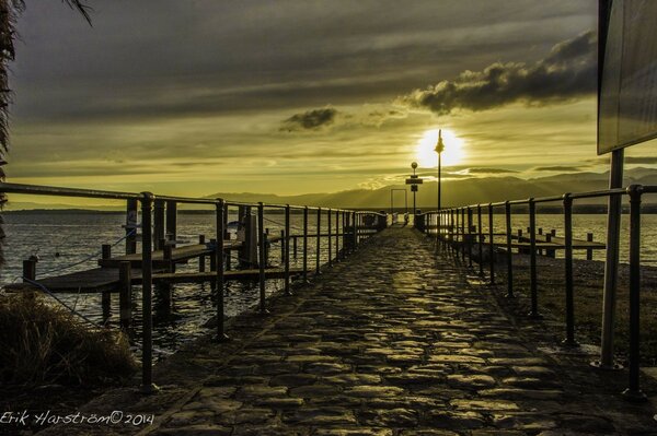 At sunset, the sea and the pier are visible