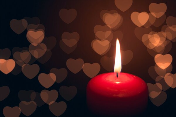 Red candle with hearts on the background