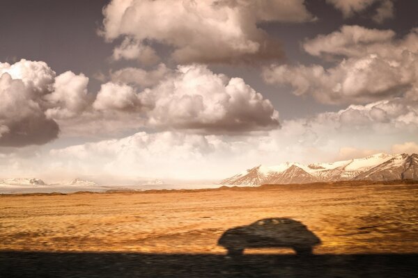 Niedrige Wolken, Feld und Berge in der Ferne