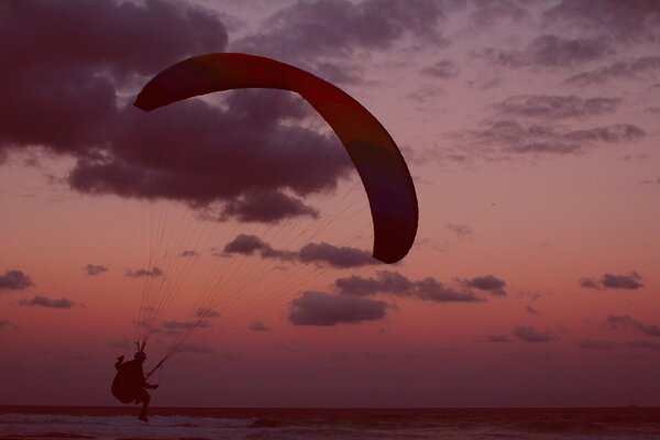 Parapente sur fond de ciel coucher de soleil rose