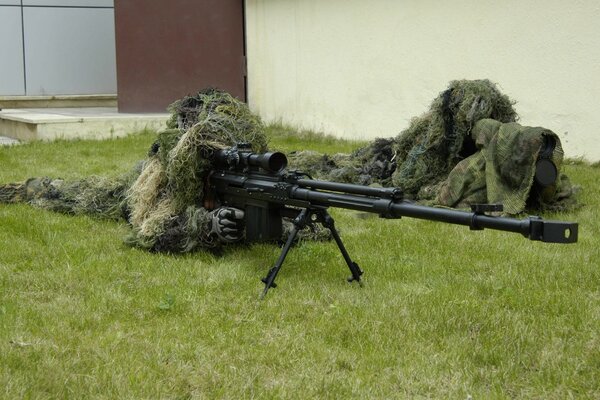 Militaire avec fusil de sniper sur l herbe