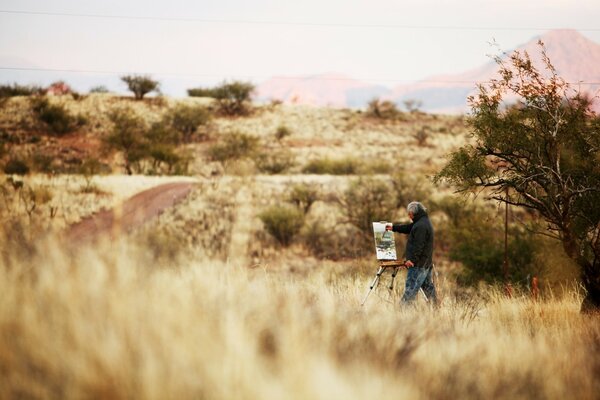 The artist was painting a picture in the field