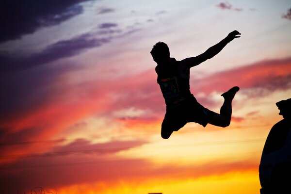 Silhouette di un ragazzo che salta sullo sfondo del tramonto