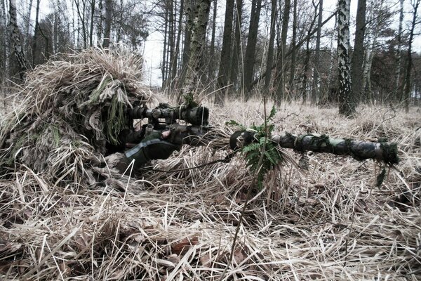 Scharfschütze in Verkleidung im Hinterhalt mit Gewehr