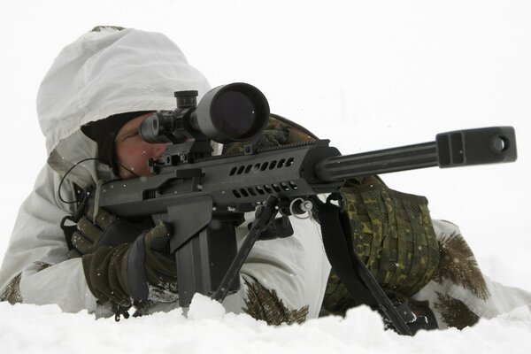 Militär mit Maschinengewehr im Schnee liegend
