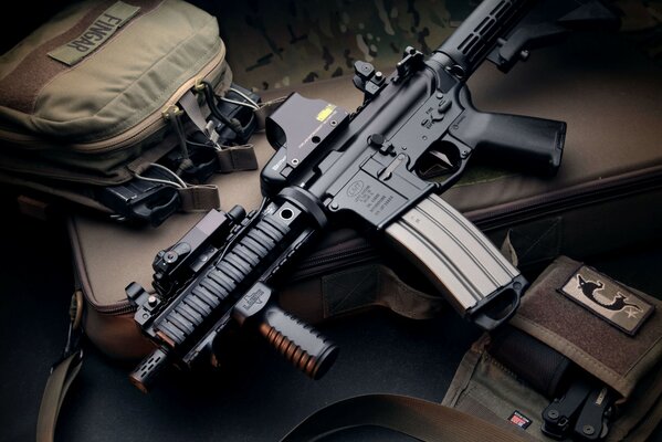 Dark background with a machine gun and a bag