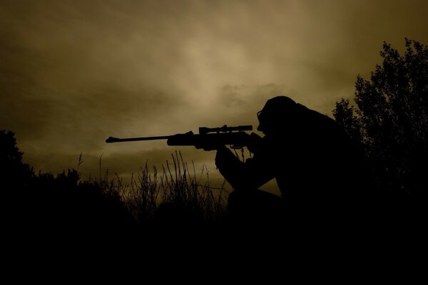 A male sniper In the bushes in the fog