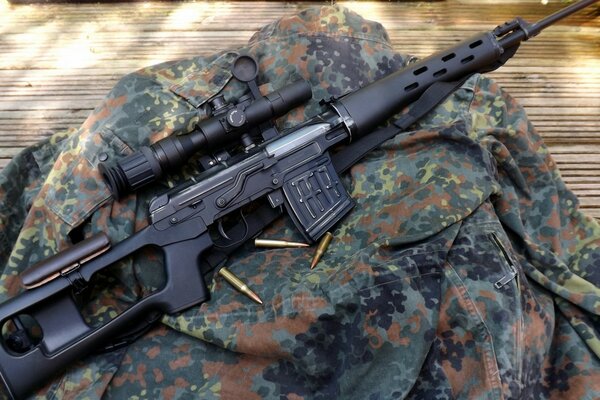 Rifle with cartridges on camouflage uniform