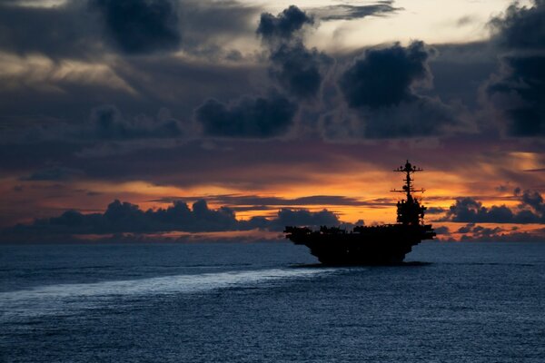 Aircraft carrier at sea during a beautiful sunset