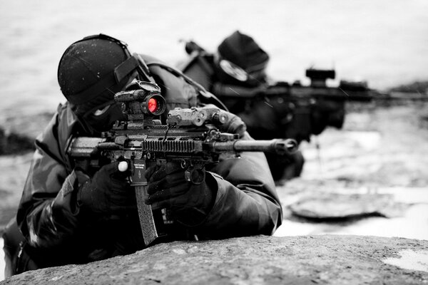 A soldier aiming a rifle in a balaclava