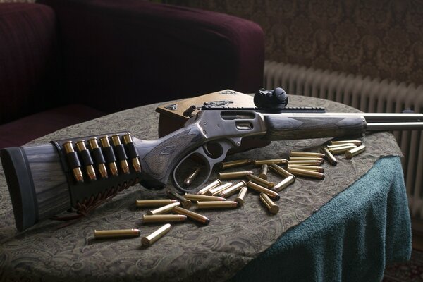 Arma rifle con munición sobre la mesa