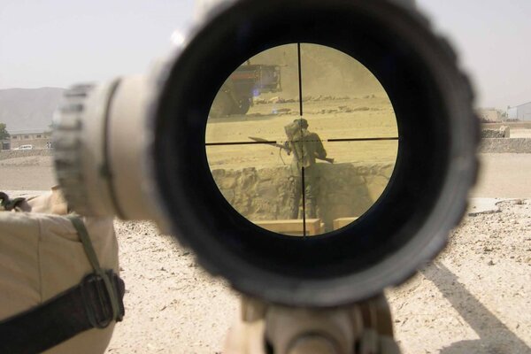 Militar en el desierto a la vista de una ametralladora