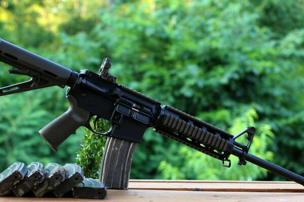 Automatic rifle with a clip on the background of the forest
