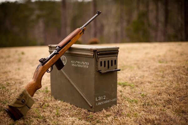 Carbine with a box on the background of the field