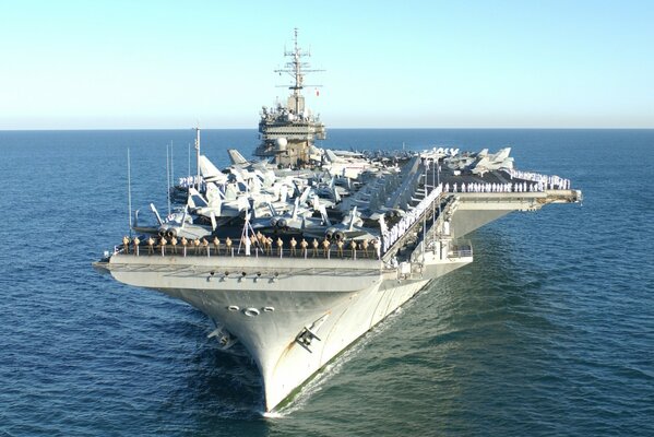 Aircraft carrier with planes on deck in the ocean