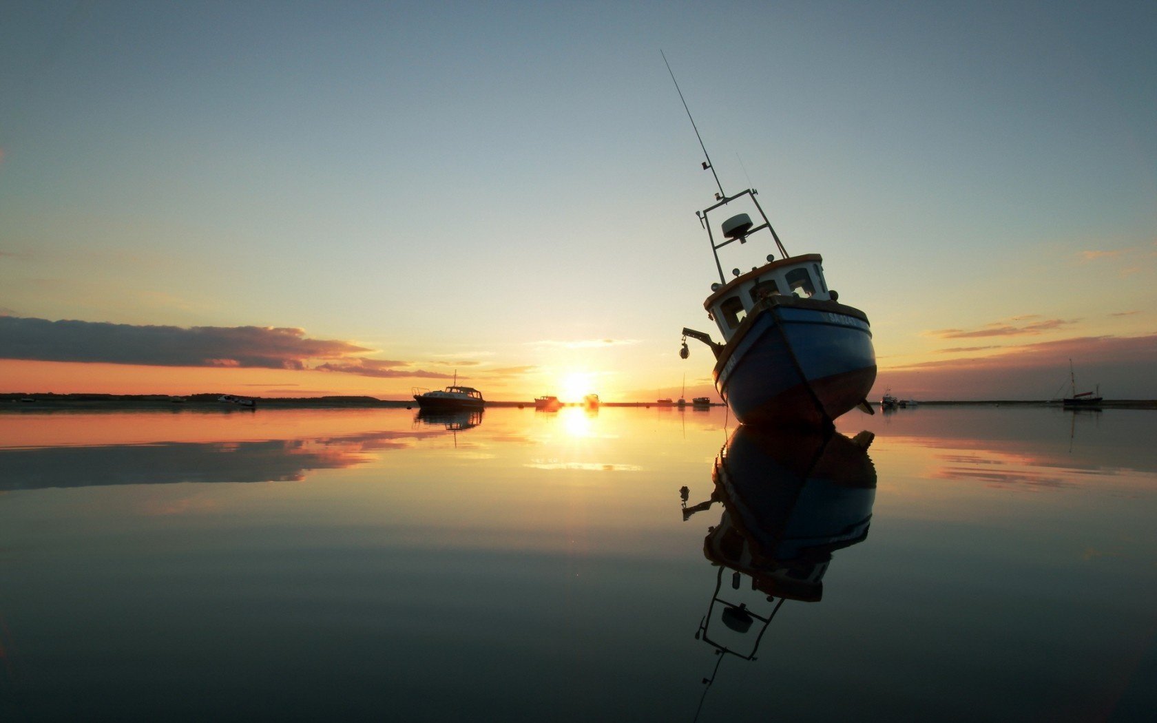 puesta de sol lago barcos