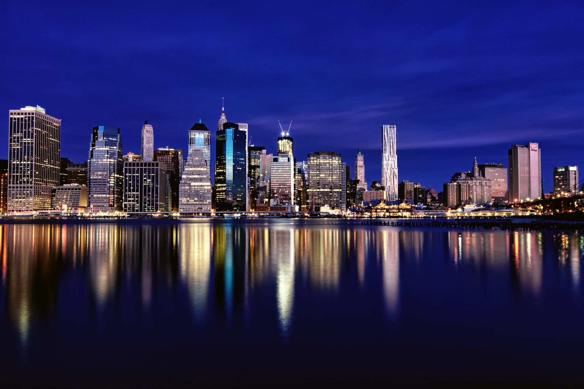 usa new york metropole gebäude wolkenkratzer nacht hintergrundbeleuchtung lichter blau himmel fluss reflexion