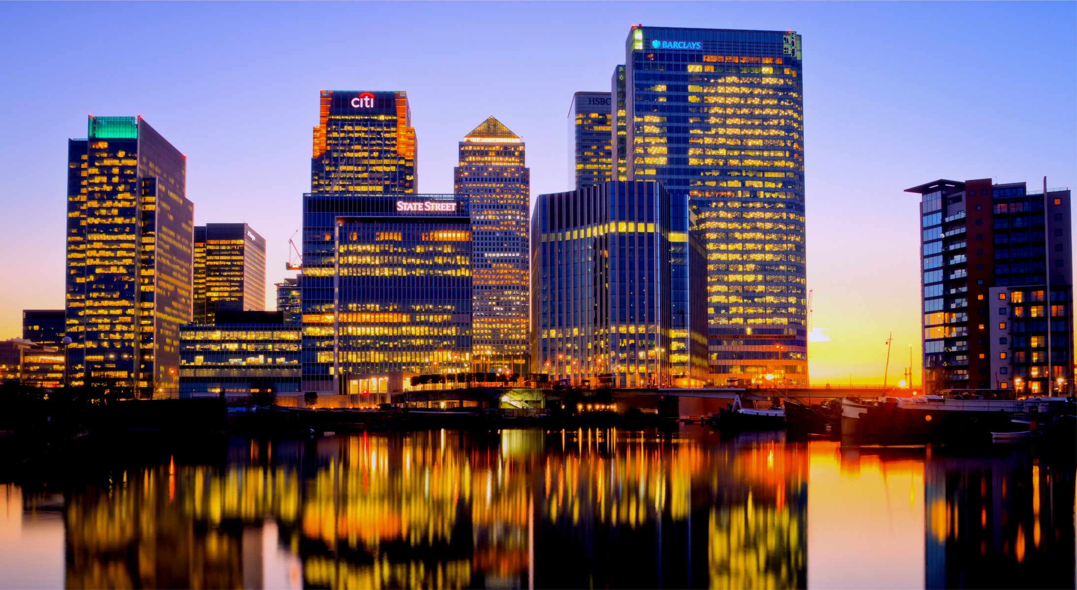 united kingdom england london canary wharf canary wharf thames evening buildings lights backlight yellow sunset blue sky river thames reflection