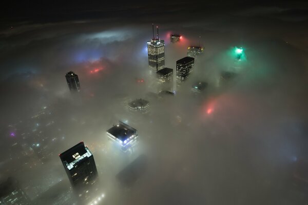 Les gratte-ciel canadiens et les lumières de la ville sont visibles à travers les nuages nocturnes