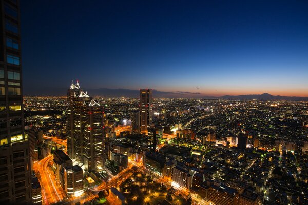 Cielo blu al tramonto sopra le luci accese di Tokyo