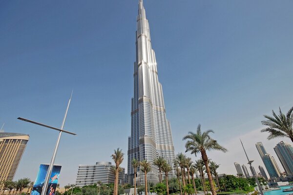Die Wolkenkratzer von Dubai unter Palmen vor dem Hintergrund des blauen Himmels