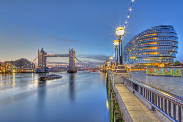 Die Promenade des abendlichen Londons. Themse und Tower Bridge im Licht der Laternen