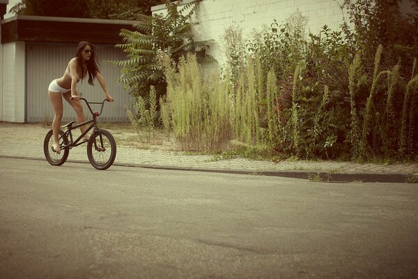 Ragazza in lingerie cavalca una bicicletta