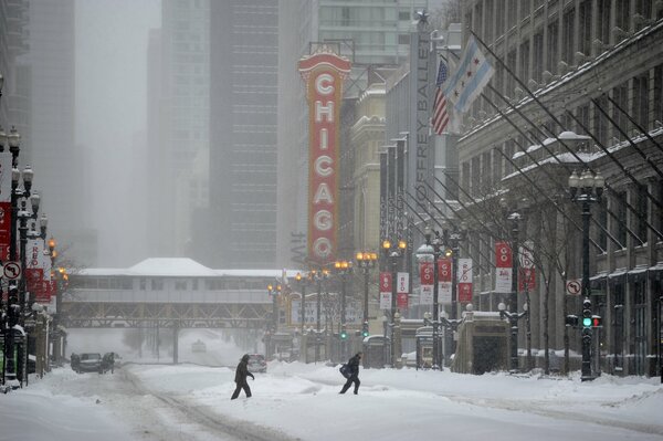 Ludzie przechodzą przez ośnieżoną ulicę zimowego Chicago