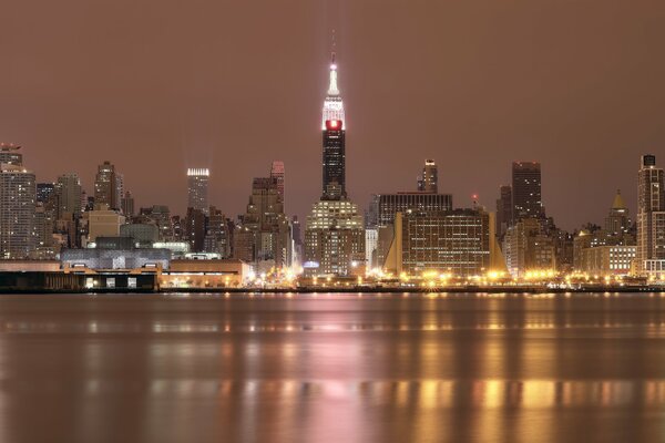 Ночная подсветка небоскрёбов в Нью-Йорке у реки