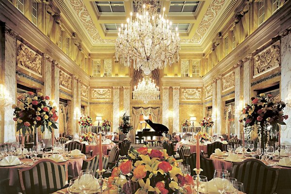 Sala con mesas decoradas con Ramos, candelabros de cristal y piano negro