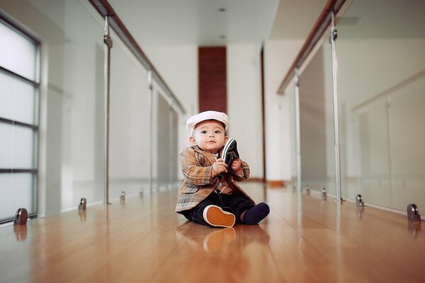 El chico con el zapato. Niño con un zapato en la mano