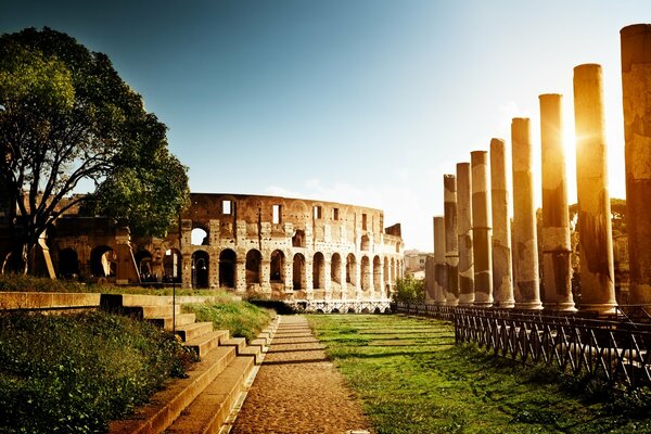 Anfiteatro italiano con el sol escondido detrás de las columnas