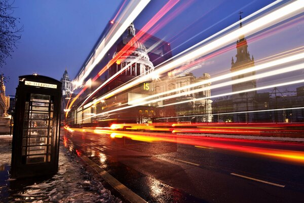 In der Stadt London werden Pfützen auf den Straßen durch das Licht der Straßen erleuchtet