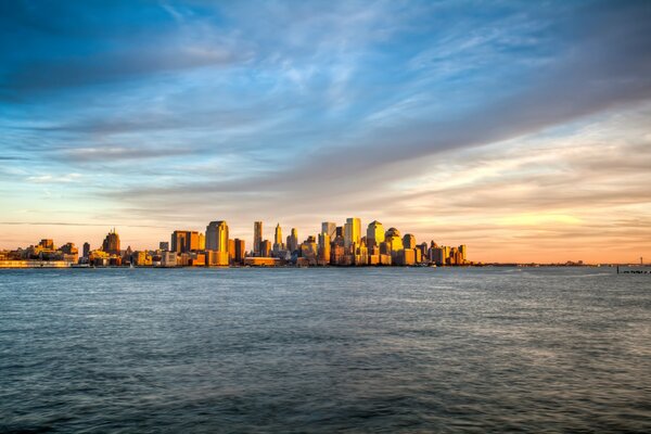 Puesta de sol sobre el mar en el contexto de Manhattan en nueva York