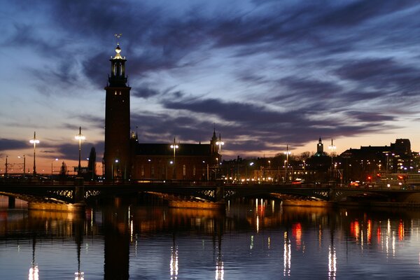 Düsterer Himmel in der Stadt. Durch die Reflexion von Laternen im Fluss