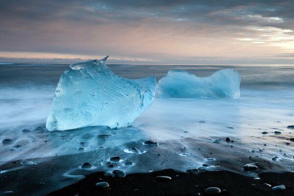 Blaue Eisblöcke vor dem Hintergrund eines düsteren Himmels