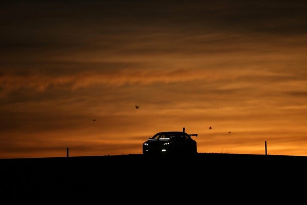 Silhouette eines Autos auf Sonnenuntergang Hintergrund