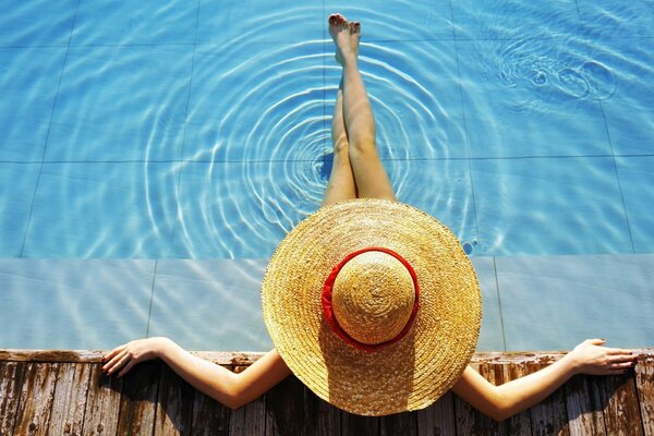 Se sentó en la piscina con un sombrero en la cabeza