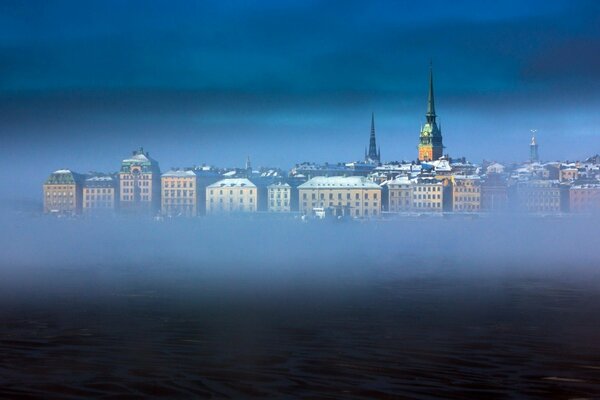 The city is in a fog and the roofs are visible