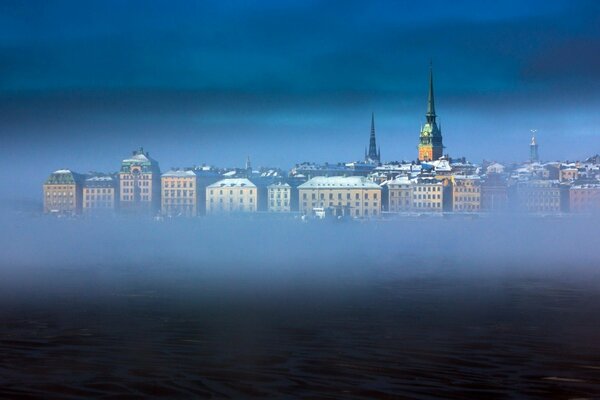 Город в тумане и виднеющиеся крыши