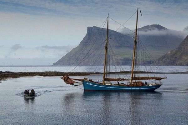 Yacht on the background of mountains in the Faroe Islands