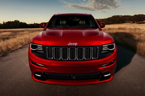 Jeep rojo grand cherokee en el fondo del campo