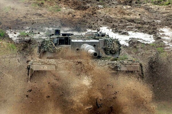 Tanque en el fondo del campo y el polvo volador