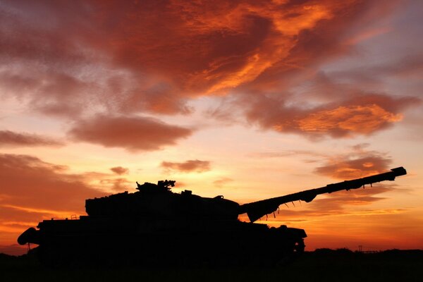 Silhouette eines großen Tanks vor dem Hintergrund eines hellen Sonnenuntergangs