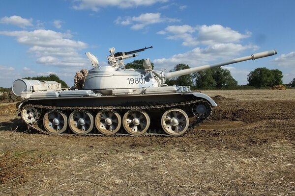 A medium, Soviet tank is walking across the field